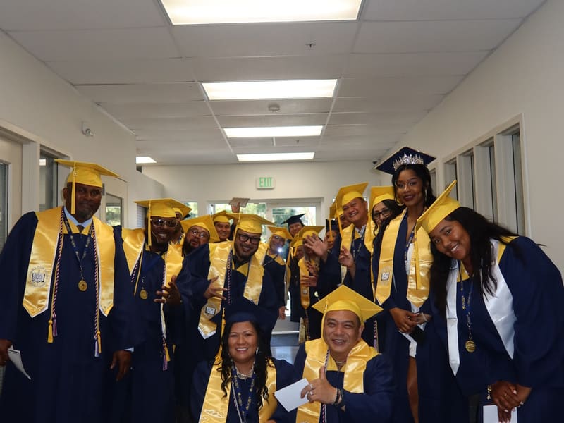 A large group of Laurus College graduates posing together indoors