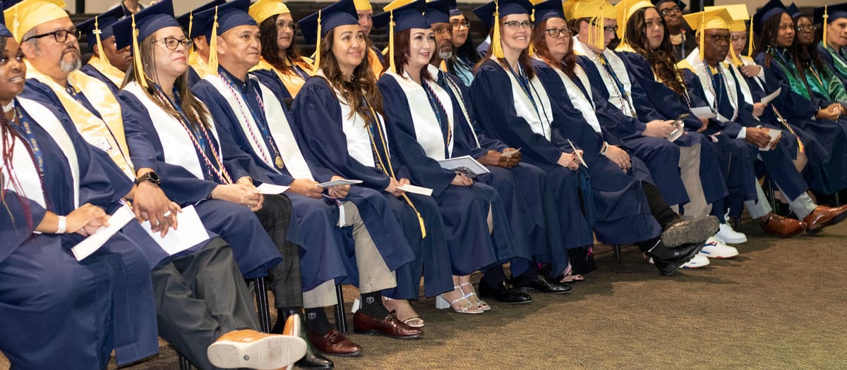 Laurus College graduates seated in caps and gowns at commencement