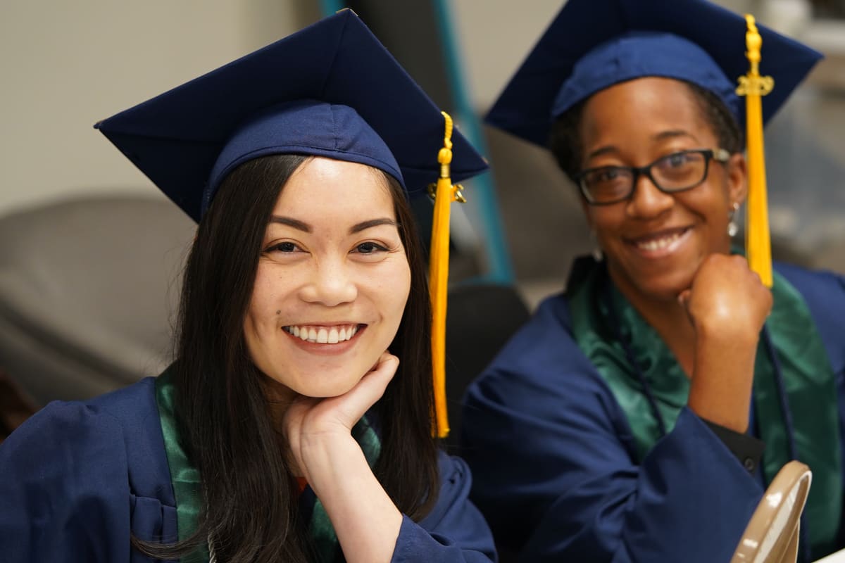 Two Laurus College graduates smiling at commencement