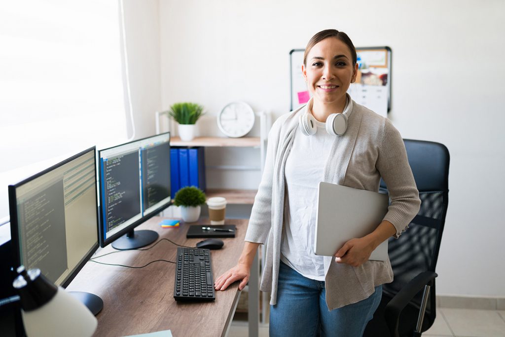 Woman standing by computer screens