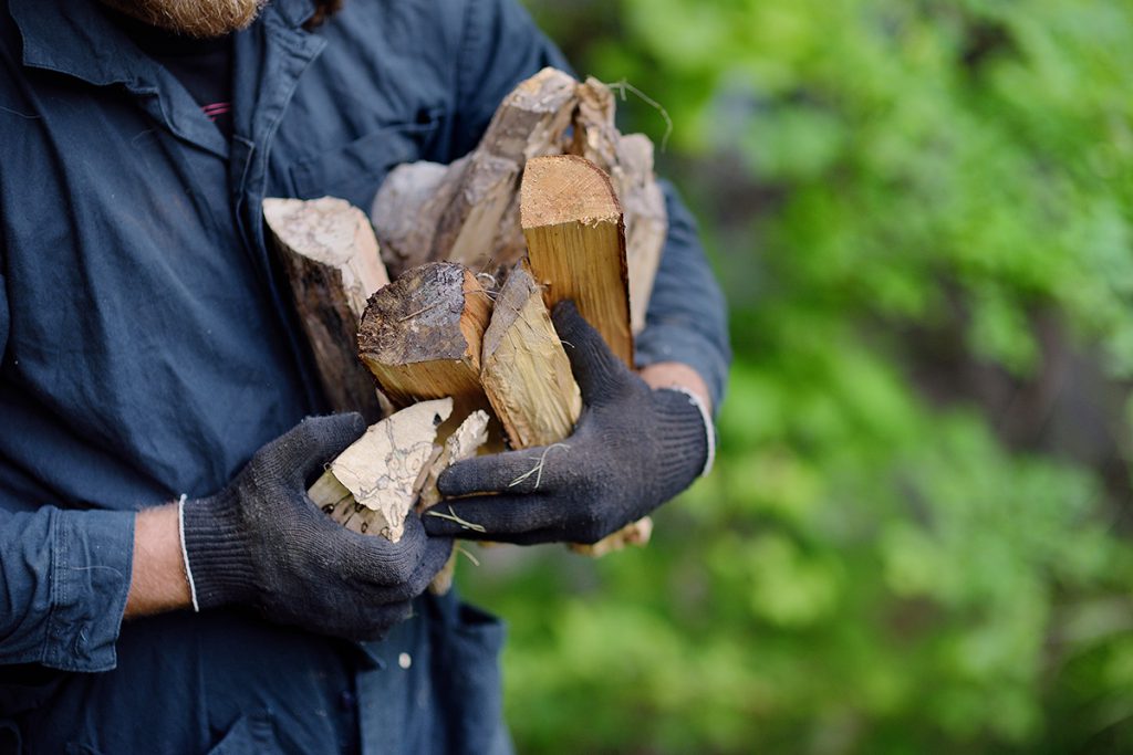 Man carrying an armful of firewood