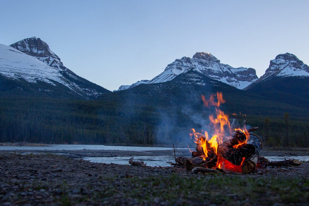 A campfire near snowy mountains